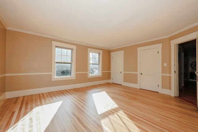 spare room featuring ornamental molding and light wood-type flooring