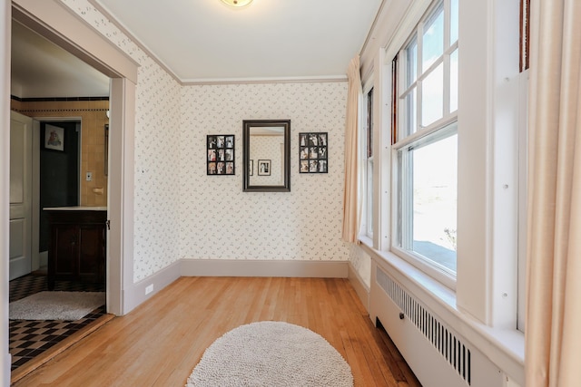 hall featuring crown molding, radiator, and light hardwood / wood-style floors