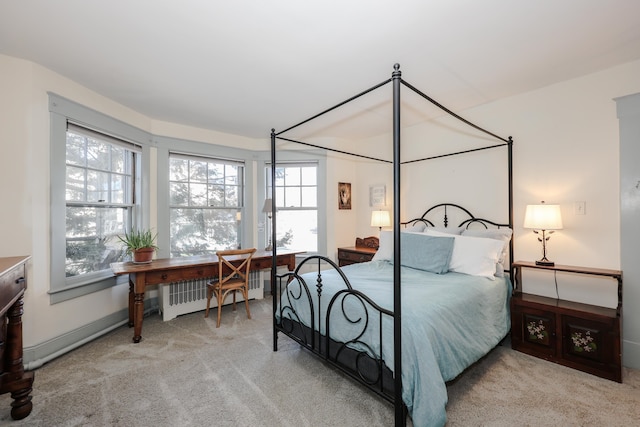 bedroom with radiator heating unit and light colored carpet