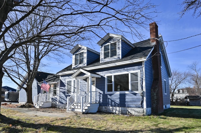 cape cod house featuring a front yard