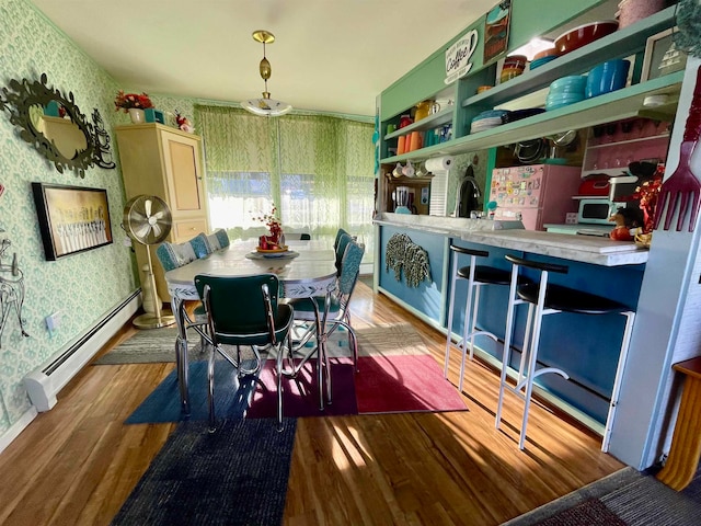 dining room with light hardwood / wood-style flooring and a baseboard heating unit