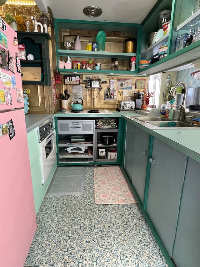 interior space featuring green cabinets, white appliances, and sink