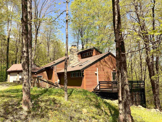 view of home's exterior with a garage and a deck