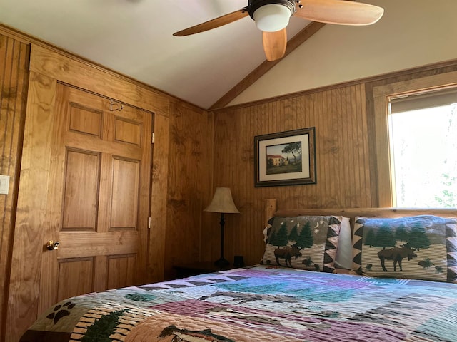 bedroom featuring ceiling fan, wood walls, and lofted ceiling