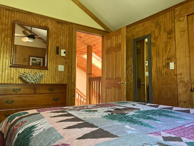 bedroom with wooden walls, a closet, ceiling fan, and lofted ceiling