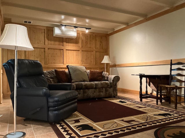 cinema room with rail lighting, beamed ceiling, a wall mounted AC, wooden walls, and light tile patterned floors