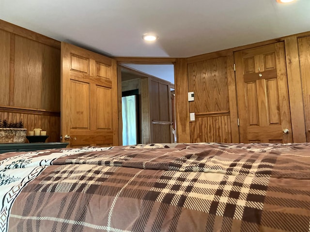 bedroom featuring wood walls