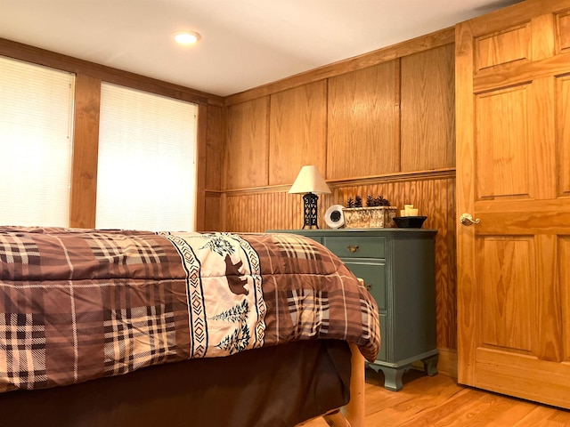 bedroom featuring wood walls and light hardwood / wood-style flooring