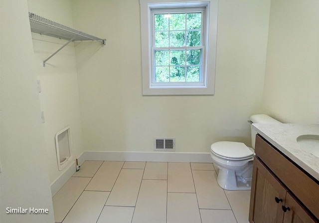 bathroom with toilet, tile patterned floors, and vanity