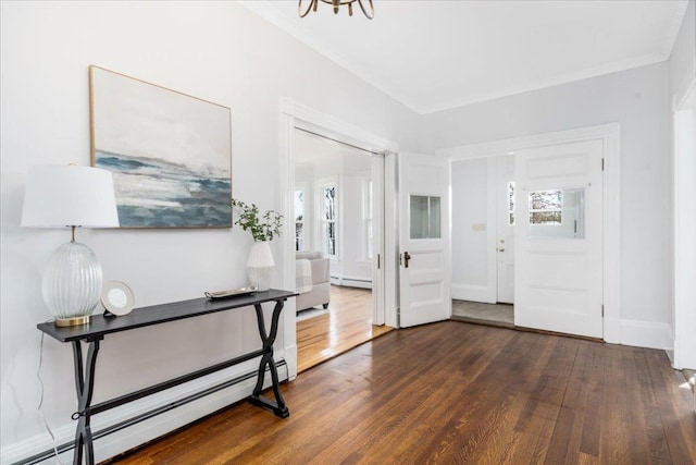 foyer entrance with baseboard heating, crown molding, and dark hardwood / wood-style floors