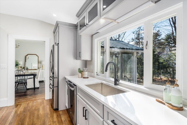 kitchen with lofted ceiling, dark wood-type flooring, sink, gray cabinets, and appliances with stainless steel finishes