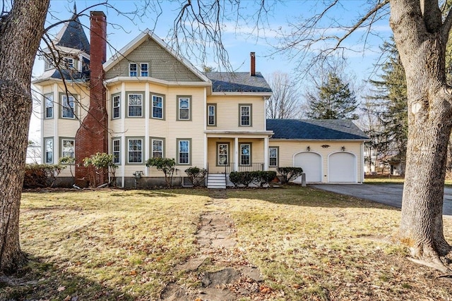 view of front facade with a porch, a garage, and a front lawn