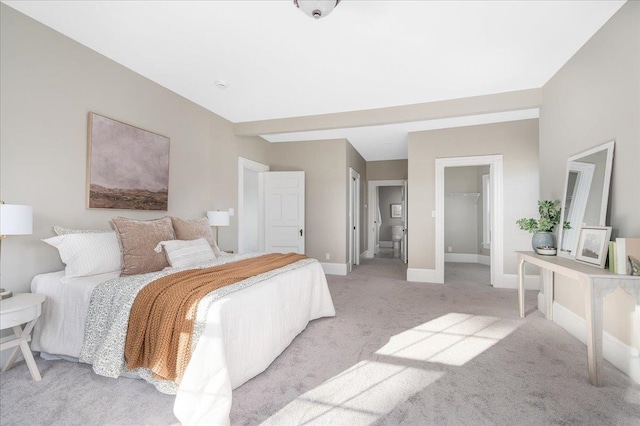 carpeted bedroom with a walk in closet and a closet