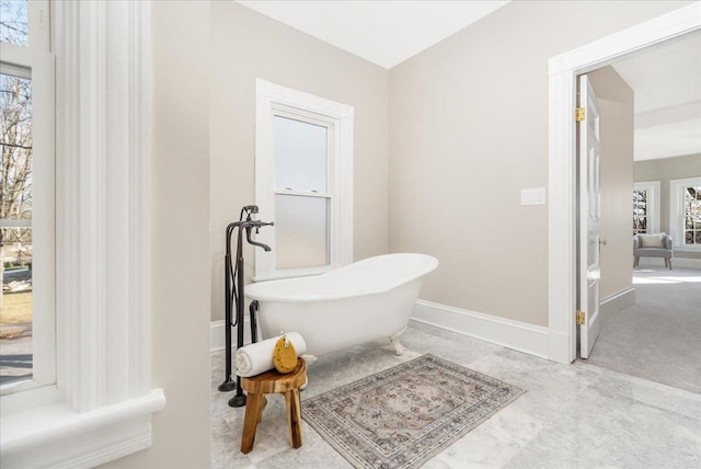 bathroom with plenty of natural light and a tub