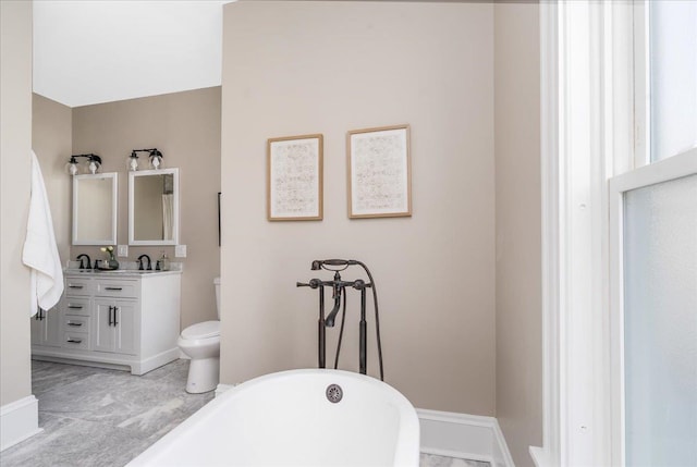 bathroom featuring a tub to relax in, vanity, and toilet