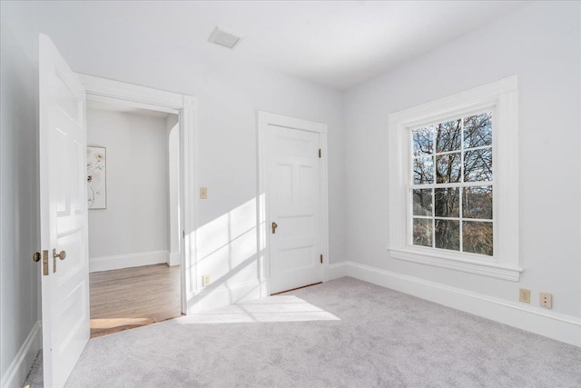 unfurnished room featuring light colored carpet