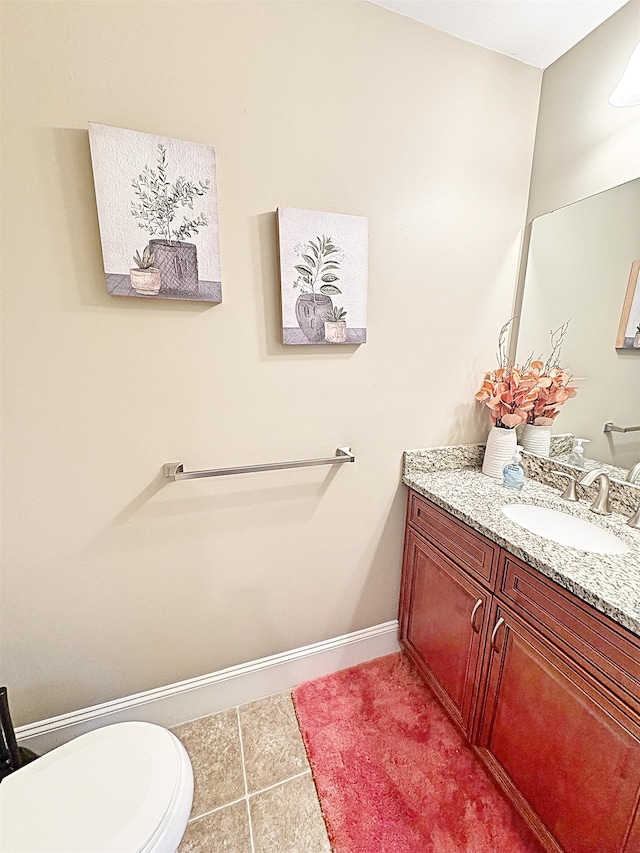 bathroom featuring toilet, vanity, and tile patterned floors