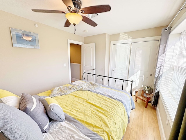 bedroom featuring light hardwood / wood-style flooring, a closet, and ceiling fan