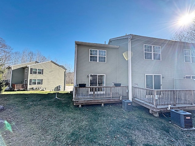 rear view of property with central AC unit, a deck, and a yard