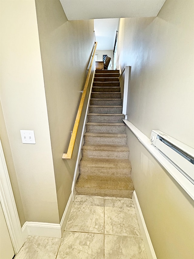 stairway featuring tile patterned floors and a baseboard heating unit