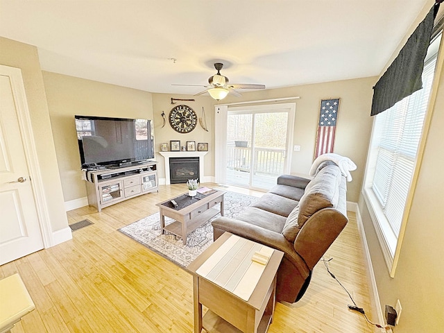 living room featuring ceiling fan and light hardwood / wood-style flooring