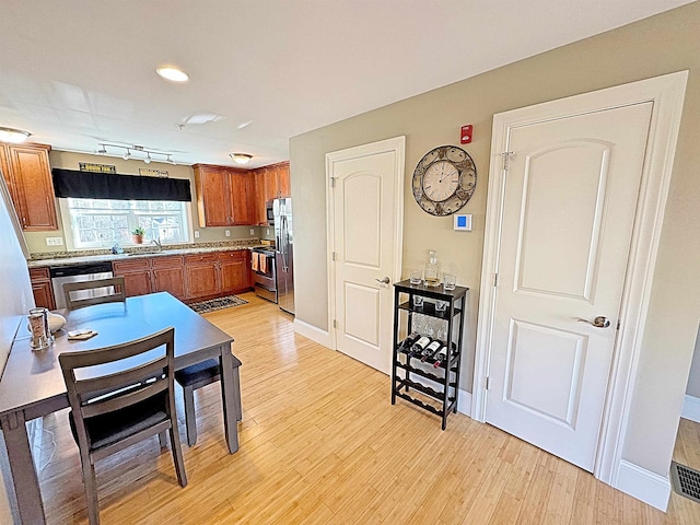 kitchen featuring sink, appliances with stainless steel finishes, track lighting, and light wood-type flooring