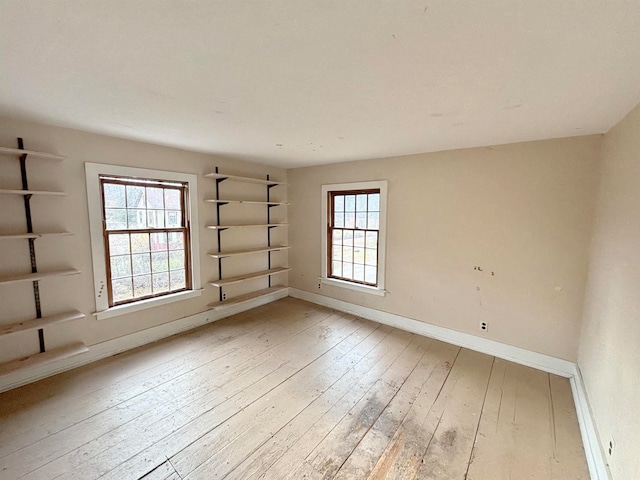 empty room featuring a wealth of natural light and hardwood / wood-style flooring