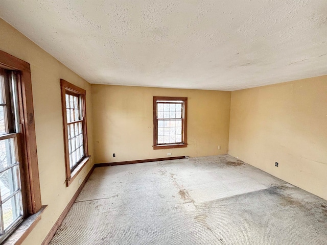 carpeted empty room with a textured ceiling