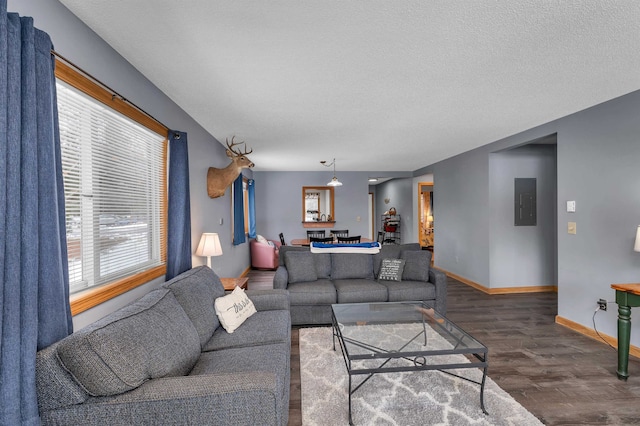 living room with electric panel, dark wood-type flooring, and a textured ceiling