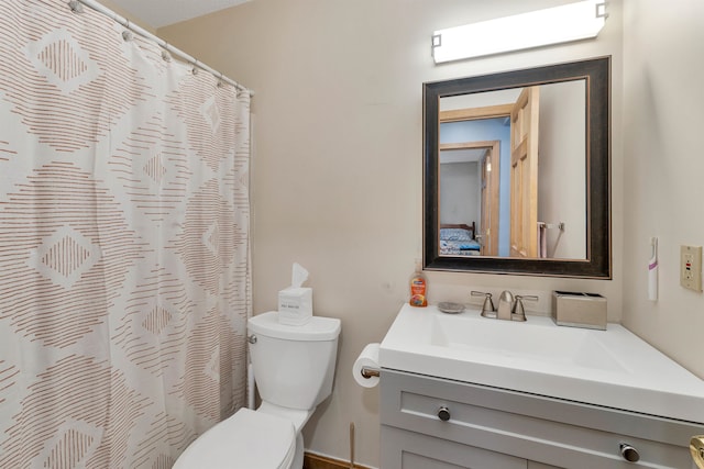 bathroom with vanity, curtained shower, and toilet