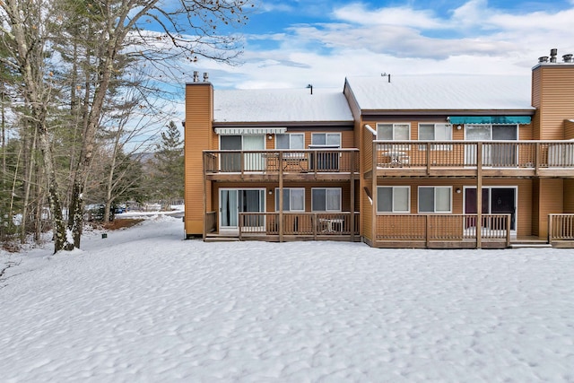 view of snow covered back of property