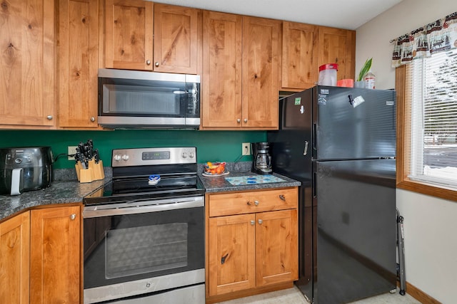 kitchen featuring dark stone countertops and stainless steel appliances