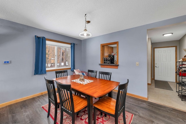 dining area featuring dark hardwood / wood-style flooring and a textured ceiling