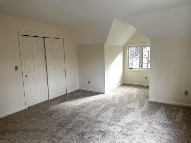 additional living space with vaulted ceiling and light carpet