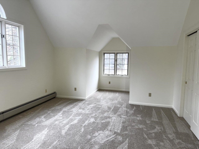 bonus room featuring a wealth of natural light, vaulted ceiling, a baseboard radiator, and carpet flooring