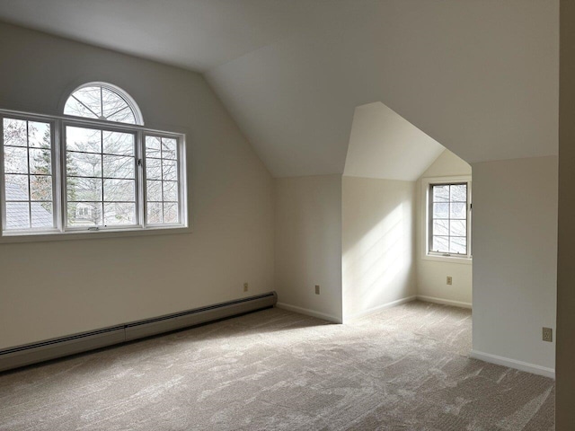 bonus room with a baseboard radiator, a healthy amount of sunlight, vaulted ceiling, and light carpet