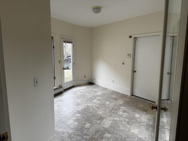 unfurnished room with a baseboard heating unit