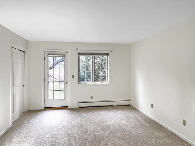 empty room featuring a baseboard radiator and light colored carpet