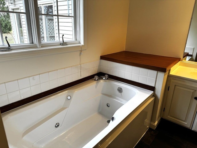 bathroom featuring vanity and a washtub