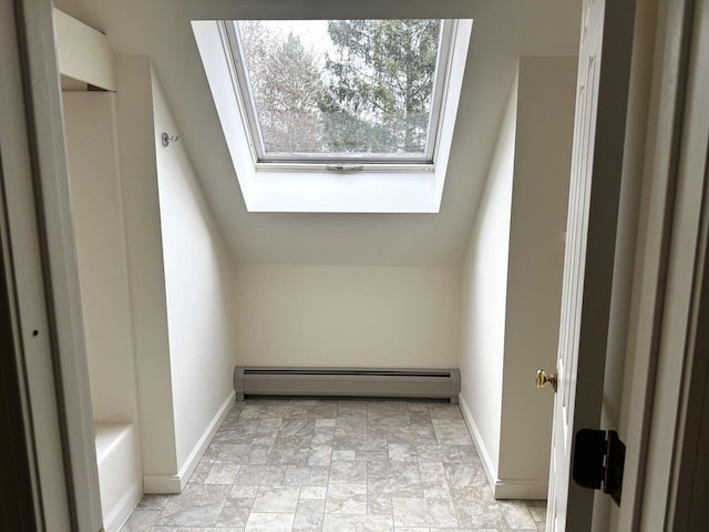 additional living space featuring lofted ceiling with skylight and baseboard heating