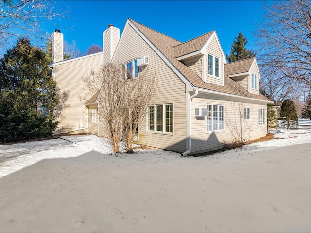 snow covered property with a wall mounted AC