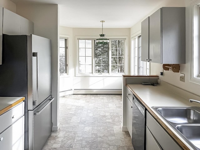 kitchen with sink, hanging light fixtures, stainless steel refrigerator, baseboard heating, and black dishwasher