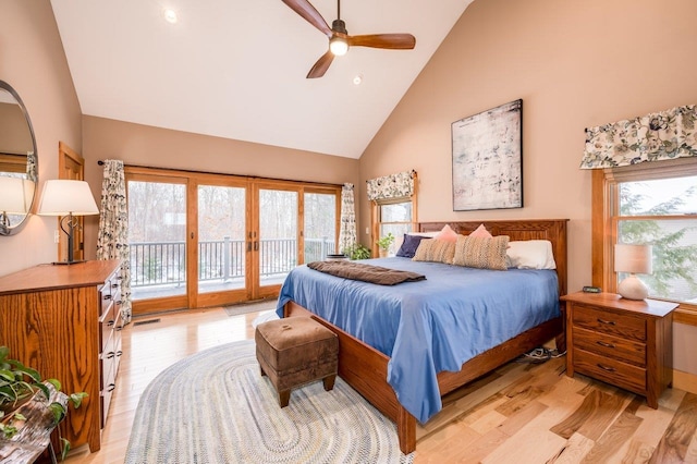 bedroom with access to exterior, light wood-type flooring, high vaulted ceiling, and multiple windows