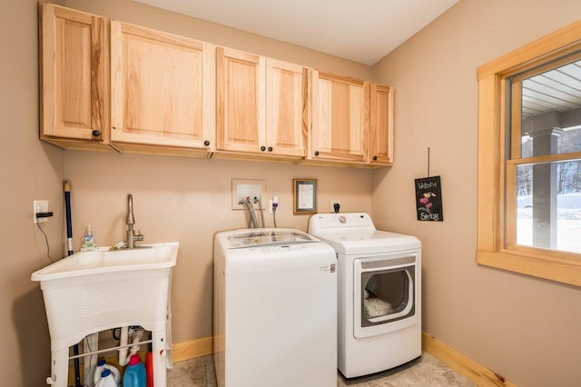 laundry room featuring cabinets, independent washer and dryer, and sink