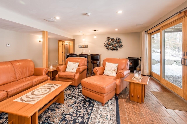 living room with hardwood / wood-style floors and a wood stove