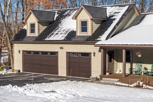 cape cod house with covered porch and a garage