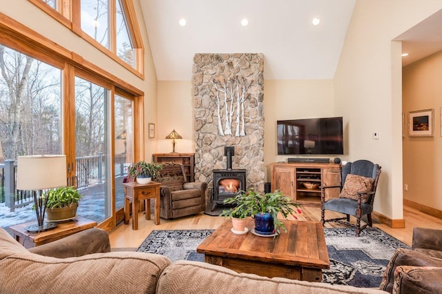 living room featuring a wood stove, high vaulted ceiling, and light wood-type flooring