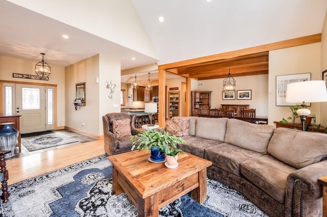 living room featuring hardwood / wood-style floors, a notable chandelier, and high vaulted ceiling