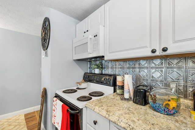 kitchen featuring white cabinets, white appliances, and a textured ceiling