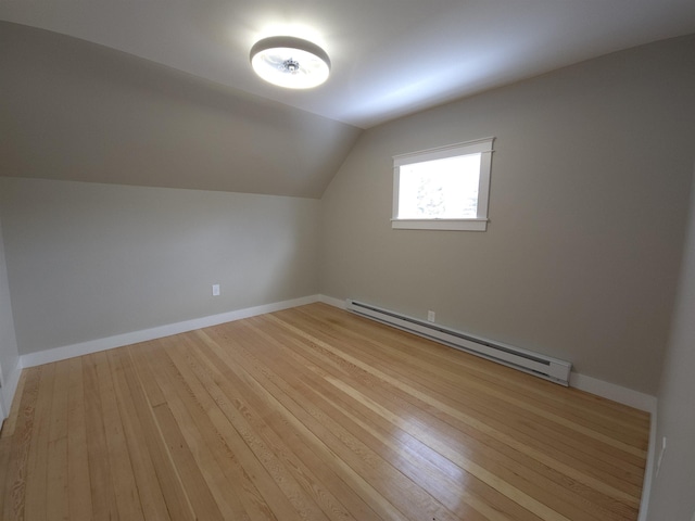 bonus room featuring light wood-type flooring, baseboard heating, and lofted ceiling